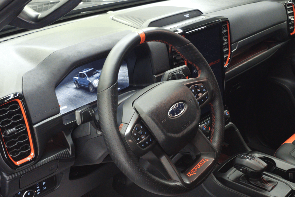 Volan Ford Raptor retapițat cu piele neagră perforată și cusături roșii.